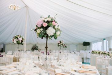 tall table arrangements of cream pink and burgundy flowers by Your London Florist